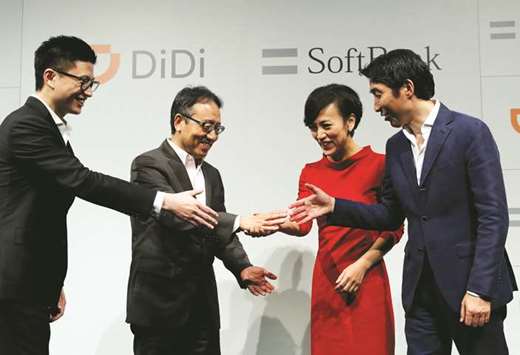 Vice president of Didi Chuxing Stephen Zhu, SoftBank Corpu2019s CEO Ken Miyauchi, president of Didi Chuxing Jean Liu and SoftBanku2019s executive Keigo Sugano shake hands after a news conference about their Japanese taxi-hailing joint venture in Tokyo yesterday. SoftBank Group chief executive Masayoshi Son blasted Japan yesterday for not allowing ride-sharing services, calling it u201cstupidu201d and saying the country was lagging overseas rivals in areas such as artificial intelligence.