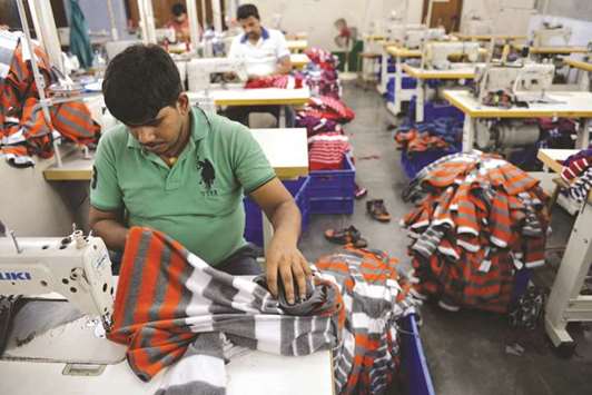 Indians work at a garment factory in Ludhiana. The slowing down of industrial output growth in India in May and higher retail inflation in June are short-term challenges which are being pro-actively acted on by the government and the RBI, and these should not be seen in any way as hurting the signs of revival in the economy significantly, an industry body said.