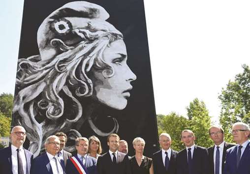 Macron with Perigueux mayor Antoine Audi (third left), French-British street artist Yseult Digan aka YZ (second right) and others in front of the mural painting depicting French national symbol u2018Marianneu2019, designed and painted by YZ, during its inauguration in the district of Bas-Toulon in Pu00e9rigueux.
