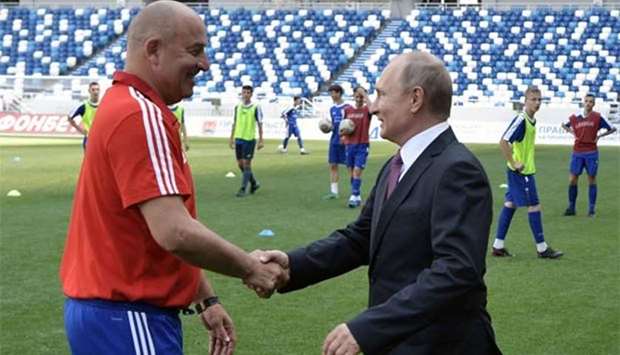 President Vladimir Putin shakes hands with Russia's football team head coach Stanislav Cherchesov as he visits the Kaliningrad Stadium on Friday.