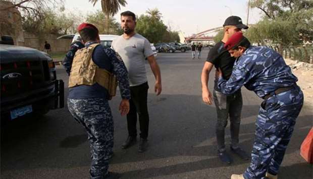 Iraqi security forces inspect people during a protest near the main provincial government building in Basra on Friday.