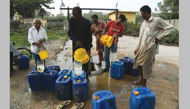 DEAR WATER: This photo taken on July 17 shows residents filling their containers with water in Karachi. Pakistan is on the verge of an ecological disaster if authorities do not urgently address looming water shortages, experts say. Official estimates show that by 2025 the country will be facing an u2018absolute scarcityu2019 of water, with less than 500cu m available per person u2013 just one-third of the water available in parched Somalia, according to the UN.