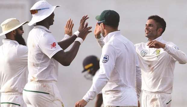 South Africau2019s Keshav Maharaj (right) celebrates with his teammates after he dismissed Sri Lankau2019s Dilruwan Perera during the first day of the second Test at the Sinhalese Sports Club (SSC) international cricket stadium in Colombo yesterday. (Below) Sri Lankan batsman Dhananjaya De Silva in action yesterday. (AFP)