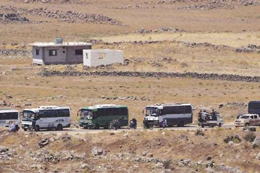 Buses line up at the Syrian side of the Israeli-Syrian border as it is seen from the Israeli-occupied Golan Heights, Israel, yesterday.