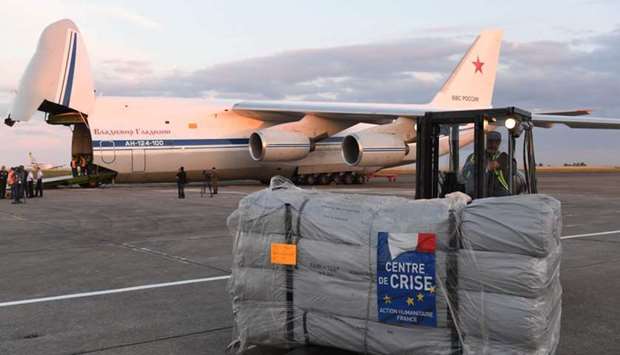 A forklift moves humanitarian supplies to be loaded onto Russian military officer stands by as an Antonov An-124 Ruslan - Widebody at the former Chateauroux-Deols Marcel Dassault Airport yesterday in central France.