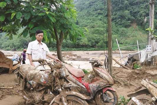 A man looks at motorbikes damaged by flash flooding in Yen Bai province of Vietnam yesterday.