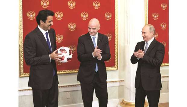 His Highness the Amir Sheikh Tamim bin Hamad al-Thani receiving the mantle for hosting the 2022 FIFA World Cup from Russian President Vladimir Putin in the presence of FIFA chief Gianni Infantino at the Kremlin Palace on the final day of the 2018 World Cup.