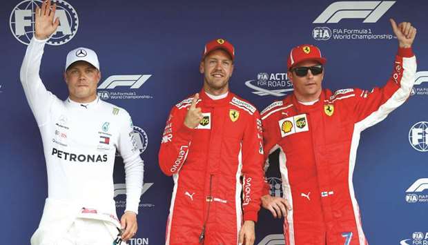 Ferrariu2019s Sebastian Vettel celebrates after qualifying in pole position with second-placed Mercedesu2019 Valtteri Bottas (L) and third-placed Ferrariu2019s Kimi Raikkonen. (Reuters)