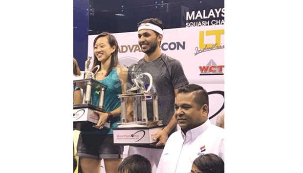Qataru2019s Abdulla al-Tamimi (centre) poses with the winneru2019s trophy after beating Tsz Fung Yip of Hong Kong in the Malaysian Open final yesterday.