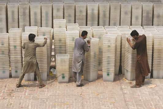 Workers sort out ballot boxes before dispatching them to polling stations ahead of general election, at the Election Commission of Pakistan office in Peshawar yesterday.