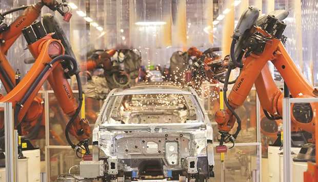 Robotic arms operate on a Volkswagen Passat inside the VW factory in Emden. German factory growth slipped to an 18-month low in June.