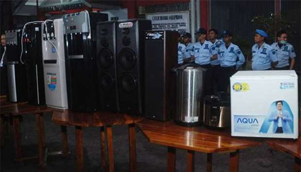 Indonesian officials standing next to home appliances used by inmates at the Sukamiskin jail in Bandung.
