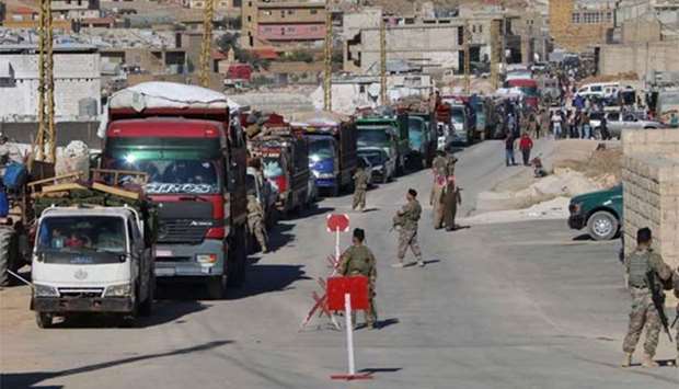 Lebanese soldiers at a checkpoint in Wadi Hmeid in the Bekaa Valley supervise a convoy transporting Syrian refugee families who left Arsal to return to their homes in Syria's Qalamoun region on Monday.