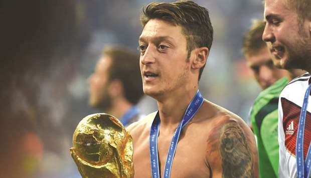 Mesut Ozil holds the World Cup trophy after leading Germany to the title in 2014. (AFP)