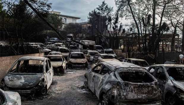 Burnt cars are seen following a wildfire at Mati, near Athens, on Tuesday.