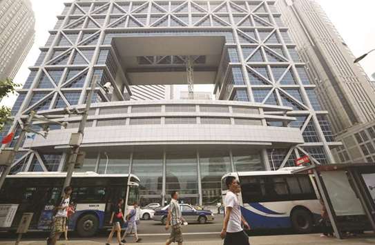 Pedestrians walk past the Shanghai Stock Exchange building in China. Shanghaiu2019s benchmark equity index fell as much as 18.6% to 2,691 points by early July, making it the worst performing major global index.
