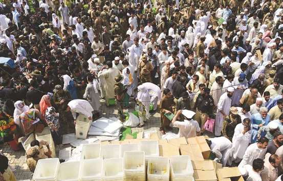 Election officials pick up ballot boxes and voting materials at a distribution centre in Peshawar.