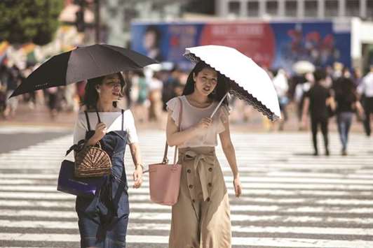 Women shield themselves from the sun with umbrellas in Tokyo yesterday as Japan suffers from a heatwave.