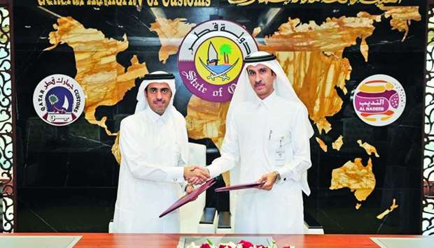 The Chairman of GAC Ahmed bin Abdullah al-Jamal and QIFU head HE Sheikh Ahmed bin Eid al-Thani exchange documents after signing the MoU.