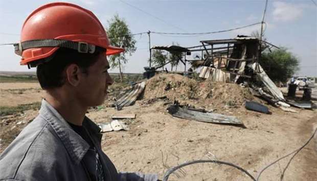 A Palestinian Electricity Authority worker inspects the damage at a Hamas observation point targeted by Israeli tank fire on the eastern outskirts of Gaza City, on Thursday.