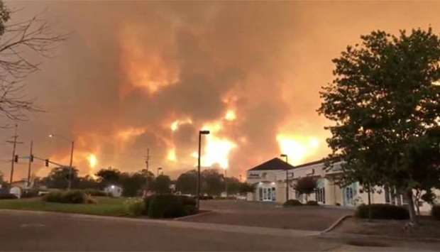 Smoke and flames are seen as a wildfire spreads through Redding, California.