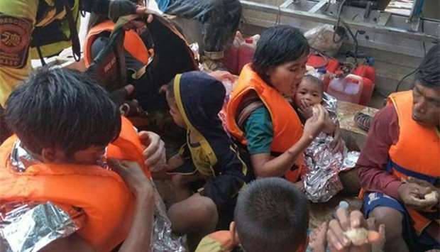 A Thai team rescuing flood survivors, including a baby trapped in a remote village, close to the swollen river in Attapeu province.