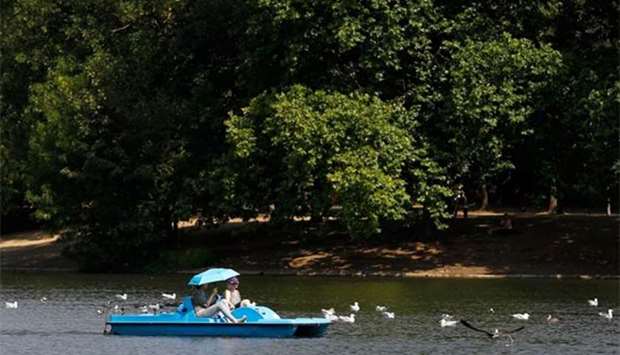 People ride a pedalo in Regent's Park, London on Friday.