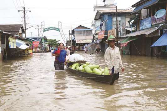 Residents use boat to transport goods on floodwaters that submerged areas of Hpa-an, capital of Karen state of Myanmar, yesterday, following heavy monsoon rains.