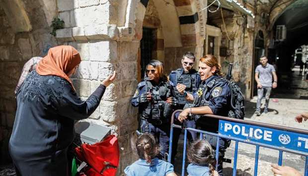 Members of the Israeli occupation forces prevent access to Palestinian pedestrians as they close down a street in the Old City of Jerusalem after clashes that took place earlier in the Al-Aqsa Mosque compound.