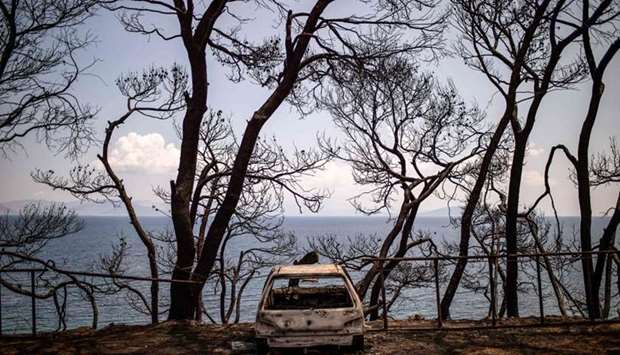 The wreckage of a burnt car is pictured on the sea side of the village of Mati, near Athens