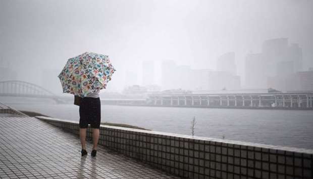 A woman protects herself from the rain with an umbrella in Tokyo
