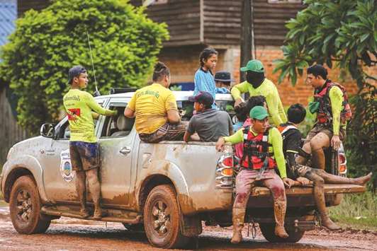 A girl (centre in blue) is transported on the back of a vehicle after being evacuated from a flooded area by rescue workers in a village in Sanamxai, Attapeu province, yesterday.