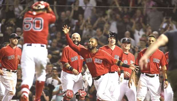 Boston Red Sox players celebrate with Mookie Betts (No 50) after his walk off home run during the tenth inning against the Minnesota Twins at Fenway Park. PICTURE: USA TODAY Sports