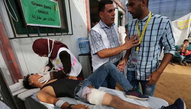 A medic tends to a wounded Palestinian during a protest at the Israel-Gaza border, in the southern Gaza Strip. Reuters