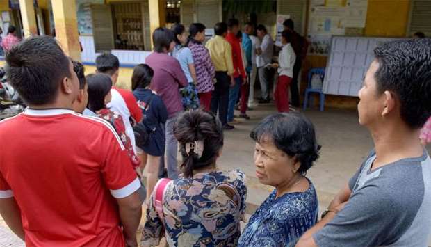 Cambodians wait in line to vote at a polling station during the country's sixth general election in 