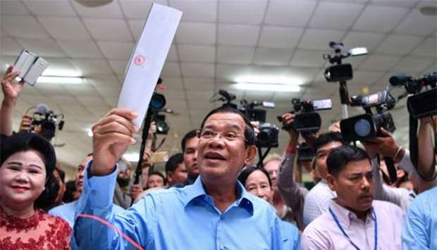Cambodia's Prime Minister Hun Sen prepares to cast his vote during the general election as his wife Bun Rany looks on in Phnom Penh on Sunday.