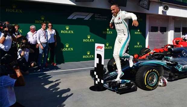 Mercedes' British driver Lewis Hamilton jumps from his car as he celebrates after winning the Hungarian Grand Prix on Sunday.