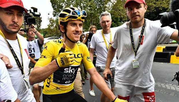 Tour de France winner Geraint Thomas (centre) wearing the overall leader's yellow jersey celebrates after the 21st and last stage of the cycling race in Paris on Sunday.