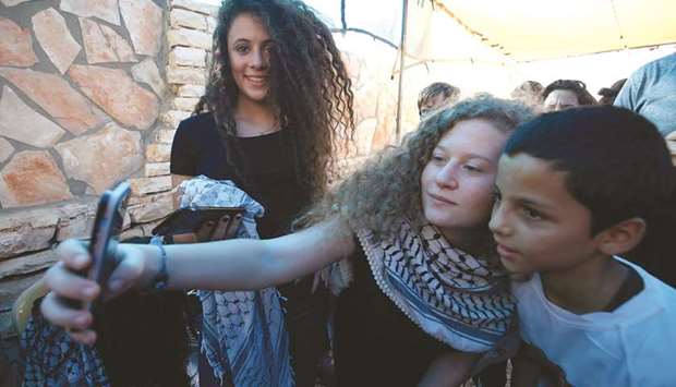 Ahed Tamimi takes a selfie with friends in the West Bank village of Nabi Saleh upon her release from prison after an eight-month sentence, yesterday.