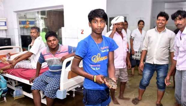 A patient's relative holding a fish after he caught it inside a waterlogged hospital ward at Nalanda Medical College and Hospital following heavy rains in Patna on Sunday.