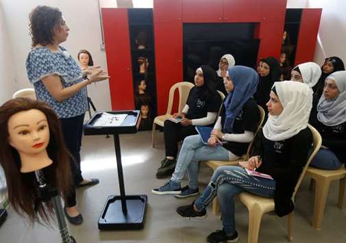 A hairdressing instructor gives tips to students at a training salon in Bar Elias town, in the Bekaa valley, Lebanon.