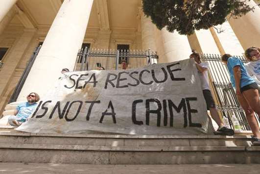 Crew members of the Sea-Watch protest outside the court house in Valletta during the arraignment of Claus-Peter Reisch, the captain of the charity ship MV Lifeline.
