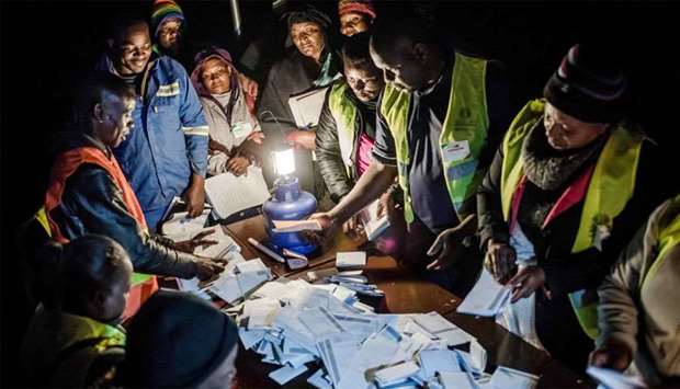 Observers check the tally of votes at a polling station for the general election in the suburb of Mbare of Zimbabwe's capital Harare