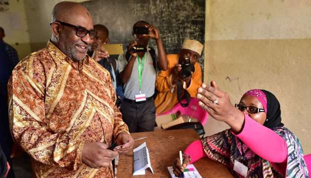 Comoros' President, Azali Assoumani arrives to a poll booth by an election official before casting his ballot during a constitutional referendum at Mitsoudje polling station, outside Moroni capital of the Comoros archipelago off Africa's east coast