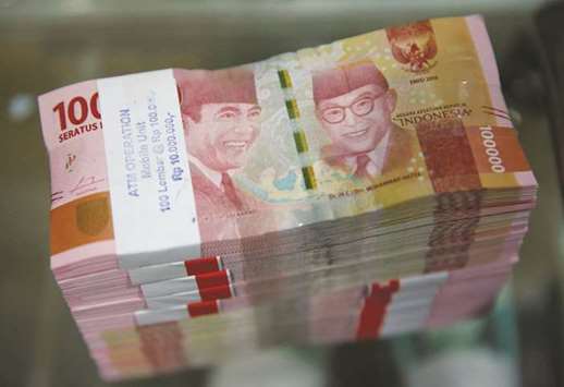 Stacks of Indonesian 100,000 rupiah bank notes are seen on a table in a counting room at Bank Mandiriu2019s headquarters in Jakarta. Indonesiau2019s President Joko Widodo sounded an alarm on the foreign exchange reserves of Southeast Asiau2019s largest economy, less than a week after he pleaded with exporters to bring home earnings they  currently keep offshore to stem the slide in the rupiah.