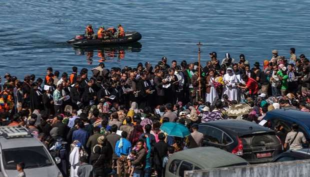 Family members of missing victims of a capsized ferry mourn during a mass memorial service at Lake Toba in North Sumatra