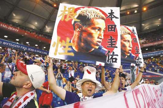Japan fans hold pictures of Keisuke Honda inside the stadium before the match against Belgium on Monday. (Reuters)