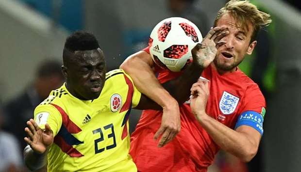 Colombia's defender Davinson Sanchez (L) heads the ball as he vies for it with England's forward Harry Kane