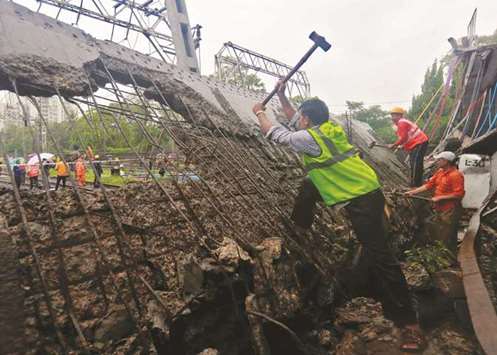 Rescuers work at the site of a bridge that collapsed over the railway tracks after heavy rains in Mumbai yesterday.