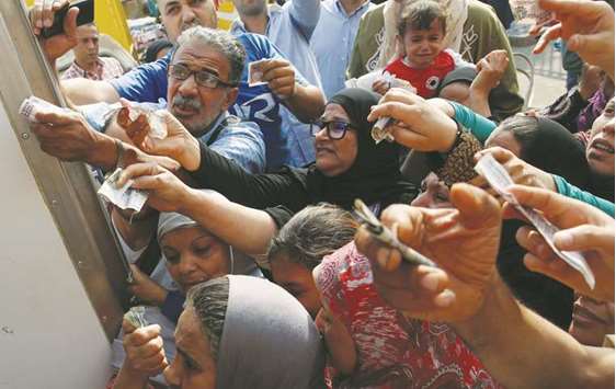 Egyptians gather to buy subsidised sugar from a government truck after a sugar shortage in retail stores across the country in Cairo (file). Egyptian officials and the IMF have said that to boost growth, the country needs to see more foreign direct investments come in.